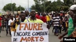 A man holds up a sign, which reads: "Faure still how many death by you," during an opposition protest calling for the immediate resignation of President Faure Gnassingbe in Lome, Togo, Sept. 6, 2017.