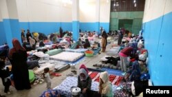 FILE - Migrants are seen at a detention center in Zawiya, west of Tripoli, Libya, April 26,2019.