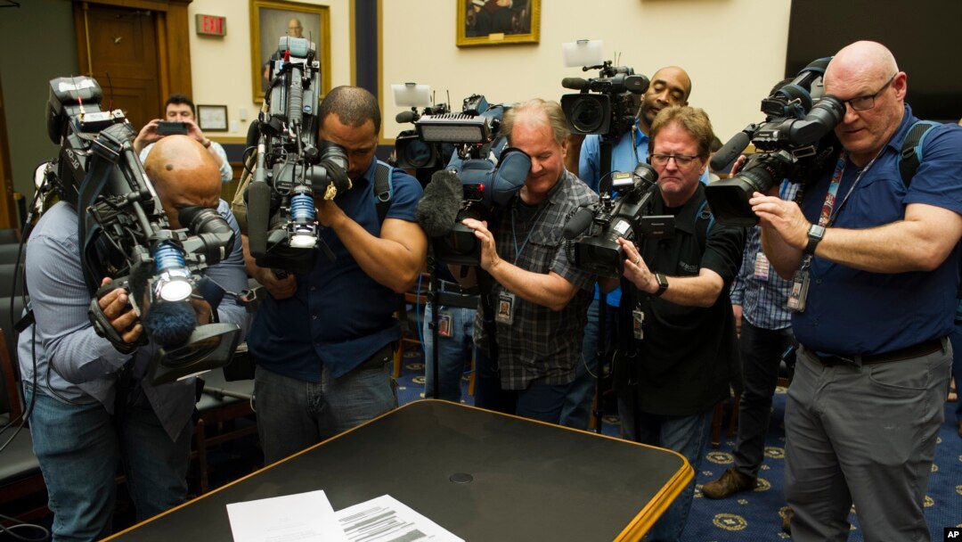 Photojournalists photograph four pages of the Mueller Report laid on the witness table in the House Intelligence Committee hearing room on Capitol Hill, April 18, 2019.