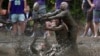 Eric Germelli, bottom, and Kevin Terban, of the Mudsharks, defend against Josh Phillips, of the Muddas, on a pass in a football game at the Mud Bowl in North Conway, New Hampshire, Sept. 8, 2024.