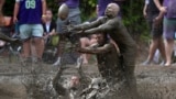 Eric Germelli, bottom, and Kevin Terban, of the Mudsharks, defend against Josh Phillips, of the Muddas, on a pass in a football game at the Mud Bowl in North Conway, New Hampshire, Sept. 8, 2024.