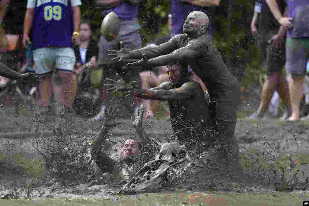 Eric Germelli, bottom, and Kevin Terban, of the Mudsharks, defend against Josh Phillips of the Muddas, on a pass in a football game at the Mud Bowl in North Conway, New Hampshire, Sept. 8, 2024.