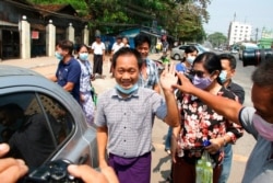 FILE - AP journalist Thein Zaw, center, waves outside Insein prison after his release, March 24, 2021, in Yangon, Myanmar. Thein Zaw was arrested while covering a protest against the coup in Myanmar.