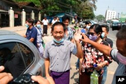 FILE - AP journalist Thein Zaw, center, waves outside Insein prison after his release, March 24, 2021, in Yangon, Myanmar. Thein Zaw was arrested while covering a protest against the coup in Myanmar.