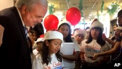 niños vestidos con gorros rojos de Navidad le entregaron al alcalde un centenar de cartas en las que expresan que su deseo para esta Navidad es que sus padres no sean deportados.