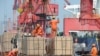 工人2019年6月7日在中国江苏省连云港市的一个港口将货物挂上起重机。