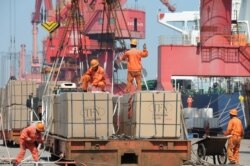 Pekerja memuat barang untuk diekspor ke crane di pelabuhan di Lianyungang, Provinsi Jiangsu, China, 7 Juni 2019. (Foto: Reuters)