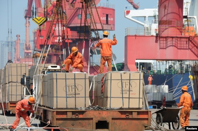 Pekerja memuat barang untuk diekspor ke crane di pelabuhan di Lianyungang, Provinsi Jiangsu, China, 7 Juni 2019. (Foto: Reuters)