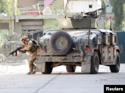 A member of Afghan security forces takes position near the site of an attack in Jalalabad city, Afghanistan, Sept. 18, 2019.