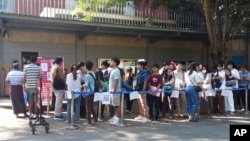 FILE - People wait in line to enter into the Thai Embassy for visa appointments in Yangon, Myanmar, Feb. 20, 2024, after the government activated a law making at least 14 million young people subject to conscription.