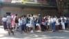 FILE - People wait in line to enter the Thai Embassy for visas in Yangon, Myanmar, on Feb. 20, 2024. Crowds of people have thronged to get passports and visas to neighboring Thailand since the government activated a law making 14 million young people subject to conscription.