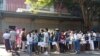 FILE - People wait in line to enter into the Thai Embassy for visa appointments in Yangon, Myanmar, Feb. 20, 2024. Crowds of people have thronged to get passports and visas to neighboring Thailand after Myanmar activated a conscription law.