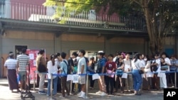 FILE - People wait in line to enter into the Thai Embassy for visa appointments in Yangon, Myanmar, Feb. 20, 2024. Crowds of people have thronged to get passports and visas to neighboring Thailand after Myanmar activated a conscription law.