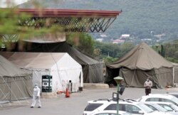 A health worker walks past tents erected at the parking lot of the Steve Biko Academic Hospital in Pretoria, South Africa, Jan. 11, 2021.