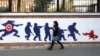 IRAN -- A woman walks past a mural painted on the outer walls of the former U.S. embassy in the Iranian capital Tehran, November 4, 2020.