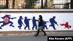 IRAN -- A woman walks past a mural painted on the outer walls of the former U.S. embassy in the Iranian capital Tehran, November 4, 2020.