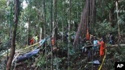 A rescue team examines the wreckage of a helicopter which crashed in Gunung Dua Sudara Bitung, in Indonesia's north Sulawesi province, August 4, 2011