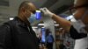 Un pasajero con mascarilla en el Aeropuerto Internacional de San Óscar Romero en San Luis Talpa, El Salvador, se somete al control de temperatura como precaución contra la propagación del nuevo coronavirus, el 12 de marzo de 2020.