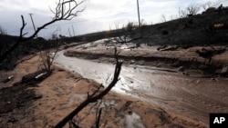 Mud and debris has flowed down normally dry Solstice Creek in an area burned by the Woolsey Fire in Malibu, Calif., Nov. 29, 2018.