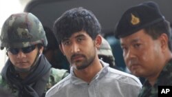 Security officials escort bombing suspect Yusufu Mieraili, center, arrested last week near the border with Cambodia as they transfer him from military to police custody at the metropolitan police headquarters in Bangkok, Thailand, Sept. 7, 2015. 