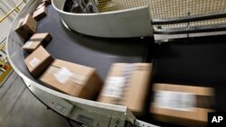 FILE - Packages that are ready to ship move along a conveyor belt at the Amazon.com 1.2 million-square-foot fulfillment center in Phoenix, Arizona, Nov. 26, 2012.