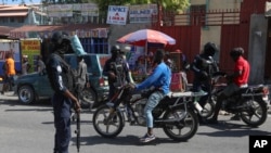 Agentes de la policía detienen a unos motociclistas mientras patrullan Puerto Príncipe, Haití, el 23 de agosto de 2024.