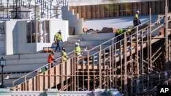 FILE - Construction crews work on the platforms where President-elect Joe Biden will take the oath of office on Jan. 20, 2021, at the Capitol in Washington, Nov. 18, 2020. 