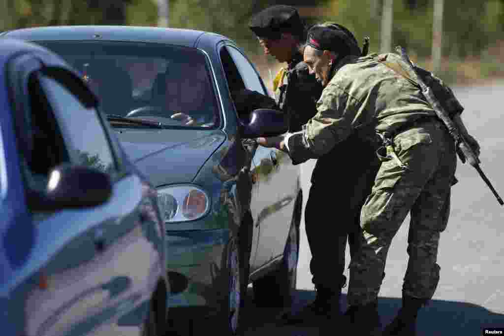Ukrainian servicemen inspect cars at a checkpoint near the town of Horlivka in eastern Ukraine, Sept.&nbsp;18, 2014.