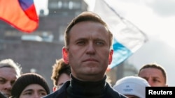 FILE - Russian opposition politician Alexei Navalny takes part in a rally to mark the 5th anniversary of opposition politician Boris Nemtsov's murder and to protest against proposed amendments to the country's constitution, in Moscow, Feb. 29, 2020.