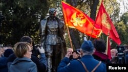 A man wearing old army uniform salutes to the monument of late Yugoslav leader Josip Broz Tito after the unveiling ceremony in Podgorica, Montenegro, Dec. 19, 2018