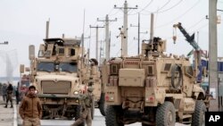 Afghan police and U.S. forces respond to a suicide car bomb attack on the Jalalabad-Kabul road in Kabul, Dec. 27, 2013. 