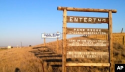 FILE - A sign hangs outside the entrance to Pine Ridge Indian Reservation in South Dakota, home to the Oglala Sioux Tribe, Sept. 9, 2012. Tribal leaders in South Dakota have denounced Governor Kristi Noem’s suggestion that drug cartels operate on reservation land.