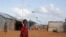 A Somali child stands under the solar powered lights at a refugee camp that were installed to help combat the rampant rapes that were occurring at night, in Mogadishu, Somalia, July 17, 2013.