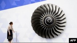Seorang perempuan mengamati model mesin jet Rolls Royce Trent di Farnborough Air Show di Hampshire, Inggris. (Foto: Dok)