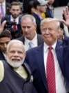 FILE - Indian Prime Minister Narendra Modi and U.S. President Donald Trump walk the perimeter of the arena floor to greet attendants after Modi's speech during the "Howdi Modi" event on Sept. 22, 2019, at NRG Stadium in Houston, Texas.