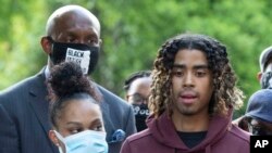 Taniyah Pilgrim listens to Messiah Young as he speaks during a news conference on the campus of Morehouse College, June 1, 2020, in Atlanta.