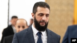 Syria's de facto leader Ahmad al-Sharaa walks in the presidential palace ahead of a meeting, in Damascus, Dec. 28, 2024.