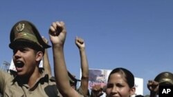 Cuban military cadets chant slogans as they march in the parade commemorating the 50th anniversary of the Bay of Pigs failed invasion along the Plaza de la Revolucion or Revolution Square in Havana, Cuba, Saturday April 16, 2011.