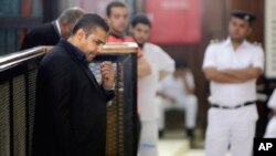 Wartawan Al-Jazeera English yang merupakan warga Kanada Mohammed Fahmy, kiri, di pengadilan di penjara Tora, di Kairo, Mesir, 25 Juni 2015. 