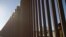 FILE - A child looks through the bars of a wall from the side of Ciudad Juarez, Mexico, in this picture taken on the side of El Paso, Texas, U.S.A., May, 25, 2019.