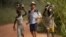 FILE - Children living in a cocoa-producing village walk back from the fields carrying wood and food stuffs on their heads on the outskirts of the town of Oume, Ivory Coast, June 30, 2005.