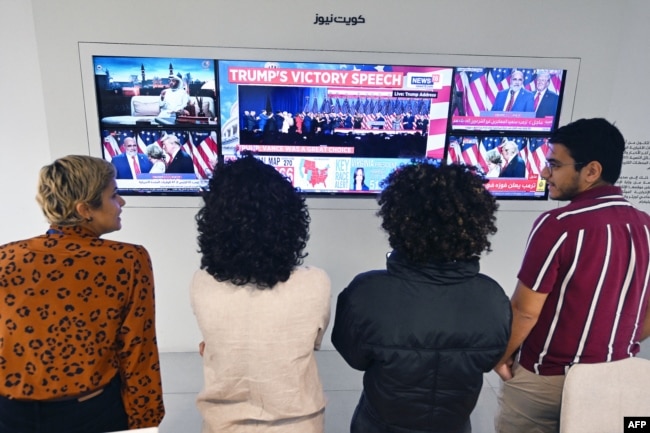 Jurnalis Kuwait menyaksikan berita hasil pemilu Amerika di layar TV besar di sebuah kantor di Kota Kuwait, 6 November 2024. (YASSER AL-ZAYYAT / AFP)