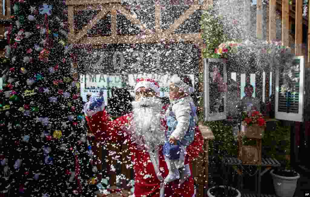 A Palestinian waiter dressed as Santa Clause holds a child for a photograph in a restaurant on the beach in Gaza City.