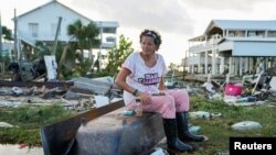 Stanovnica Floride Džuel Baget sedi na prevrnutoj kadi u sred ruševina kuće koju je izgradio njen deda i u kojoj su živele tri generacije njene porodice u mestu Horšu Bič na Floridi, 30. avgusta 2023. (Foto: Rojters/Cheney Orr) 