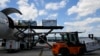 FILE - Avianca Cargo employees unload flower crates from a plane at Miami International Airport in Miami, Florida, on Feb. 12, 2024. The U.S. trade deficit in July expanded to its largest since mid-2022, according to government data released on Sept. 4, 2024.