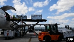 FILE - Avianca Cargo employees unload flower crates from a plane at Miami International Airport in Miami, Florida, on Feb. 12, 2024. The U.S. trade deficit in July expanded to its largest since mid-2022, according to government data released on Sept. 4, 2024.