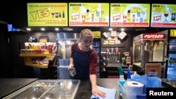 A worker disinfects high-touch areas for the reopening of a cinema following the easing of the coronavirus disease (COVID-19) restrictions in Melbourne, June 22, 2020. 