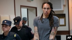 FILE: WNBA star and two-time Olympic gold medalist Brittney Griner is escorted from a court room ater a hearing, in Khimki just outside Moscow. 8.4.2022