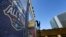 FILE - A worker attaches a banner to a scaffolding in New Orleans in preparation of the NBA All-Star basketball game, Feb. 13, 2014.
