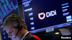 FILE - A trader works during the IPO for Chinese ride-hailing company Didi Global Inc on the New York Stock Exchange (NYSE) floor in New York City, June 30, 2021. 